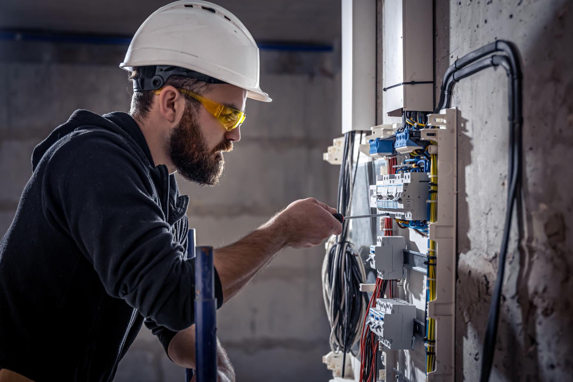 Homme devant un panneau d'éléctricité